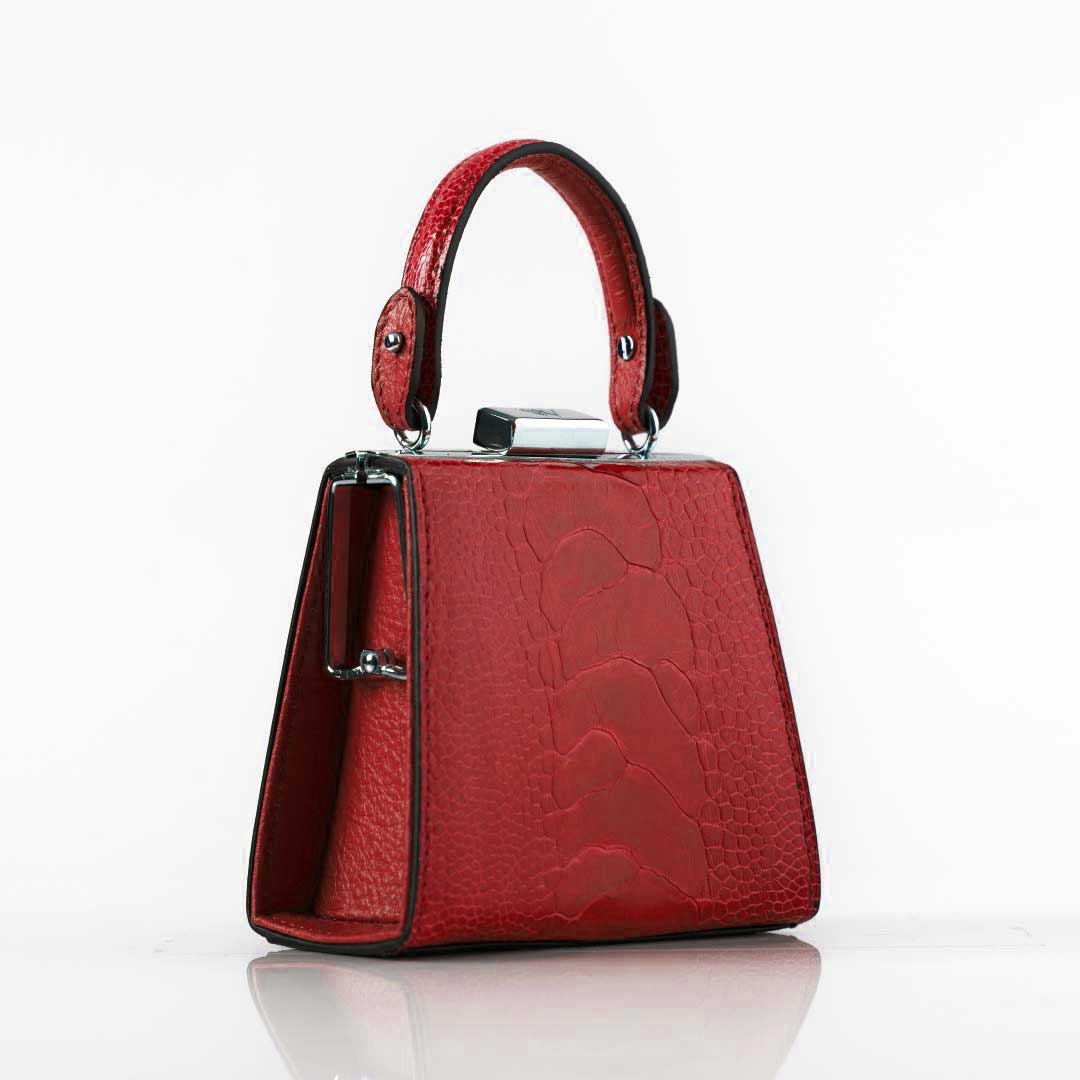 Red handbag with a textured surface on a white background