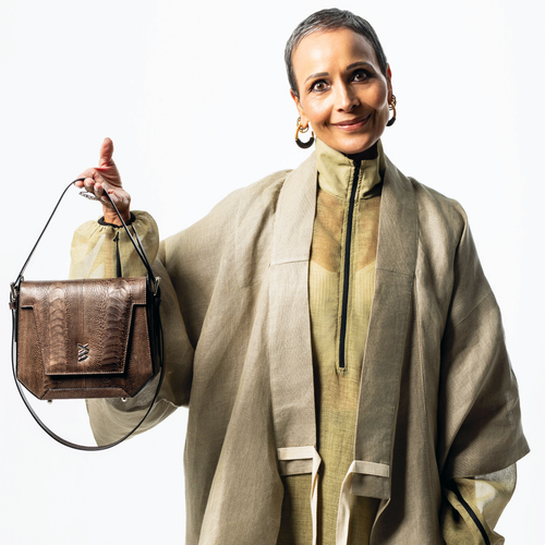 Woman holding a brown handbag against a white background