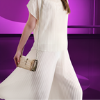 Woman in a white dress holding a beige handbag against a purple background