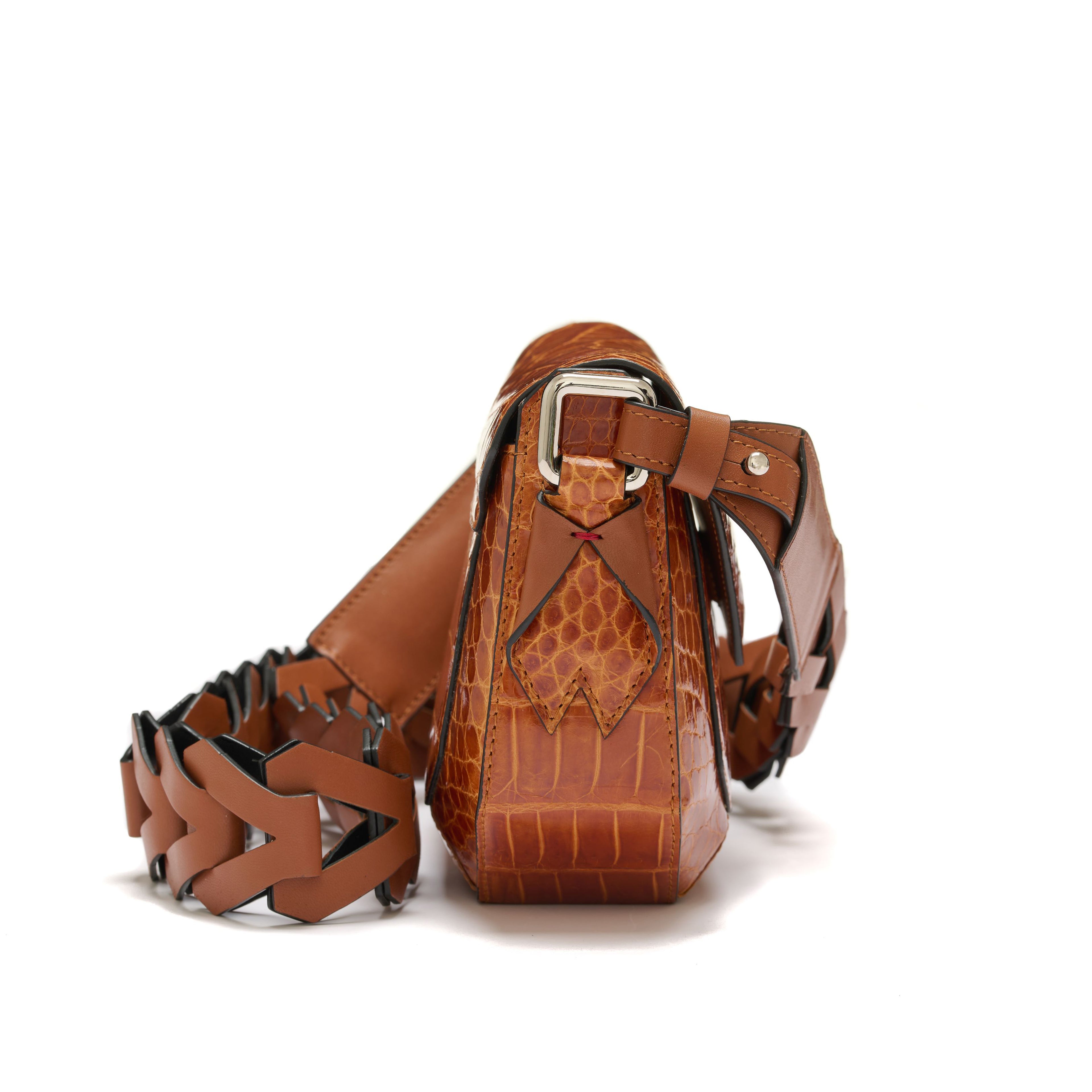 Brown leather handbag with unique strap design on a white background