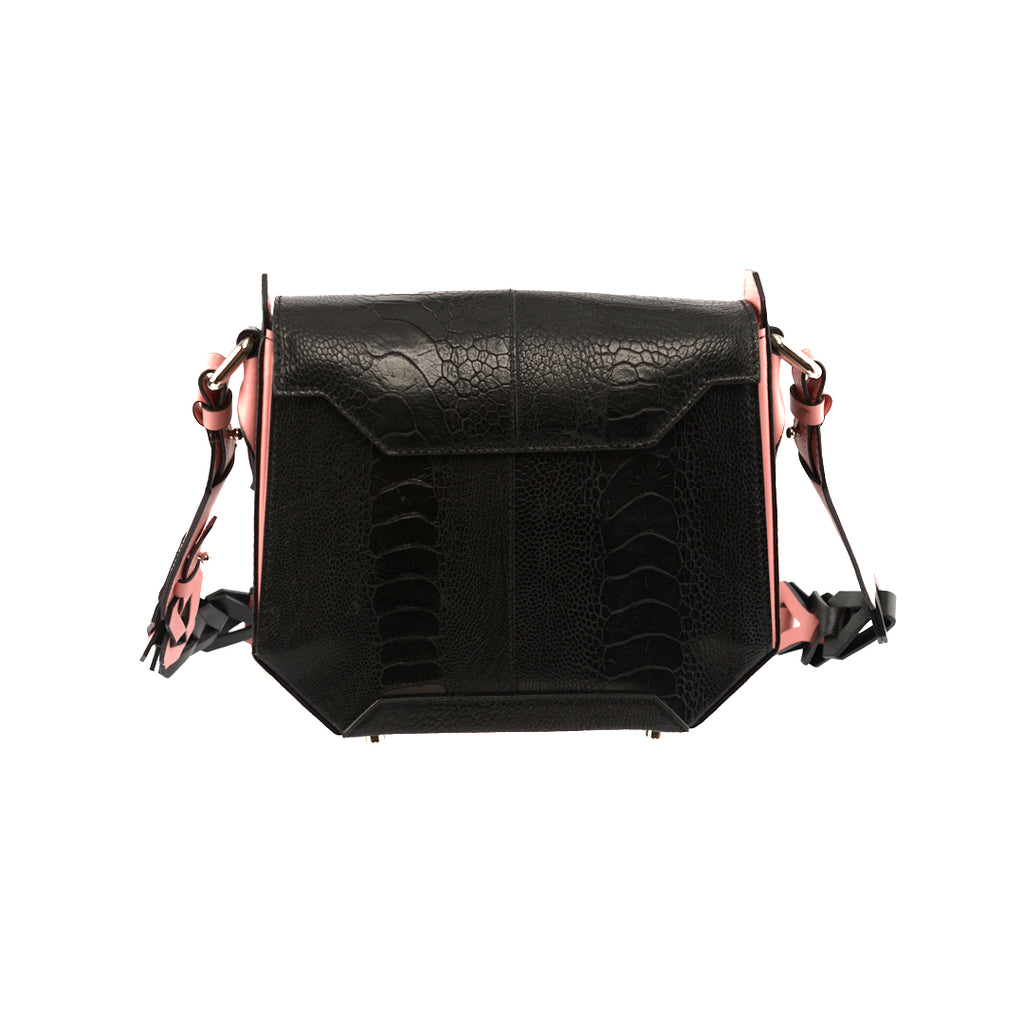 Black handbag with light pink gussets and a structured design, featuring a magnetic top closure and a removable link strap.