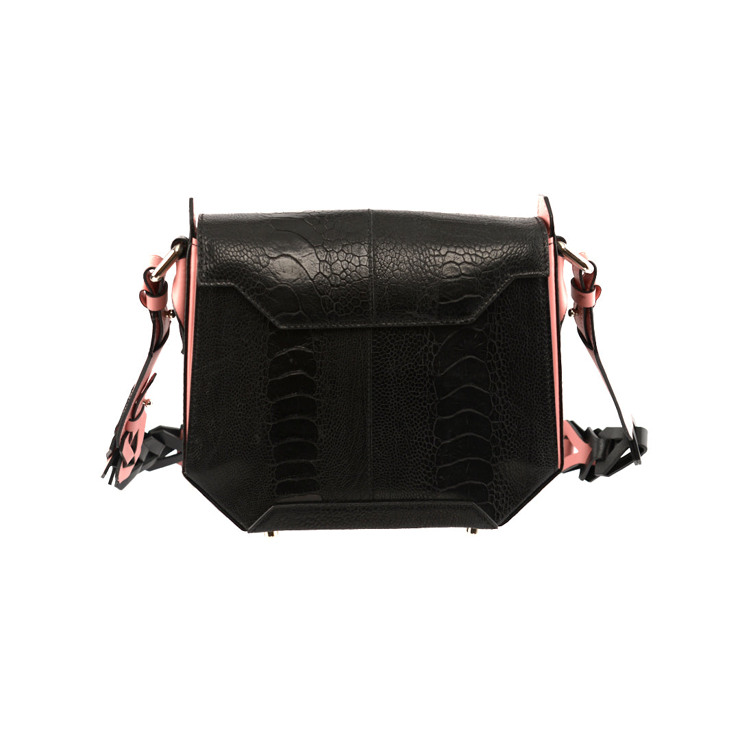 Black handbag with light pink gussets and a structured design, featuring a magnetic top closure and a removable link strap.
