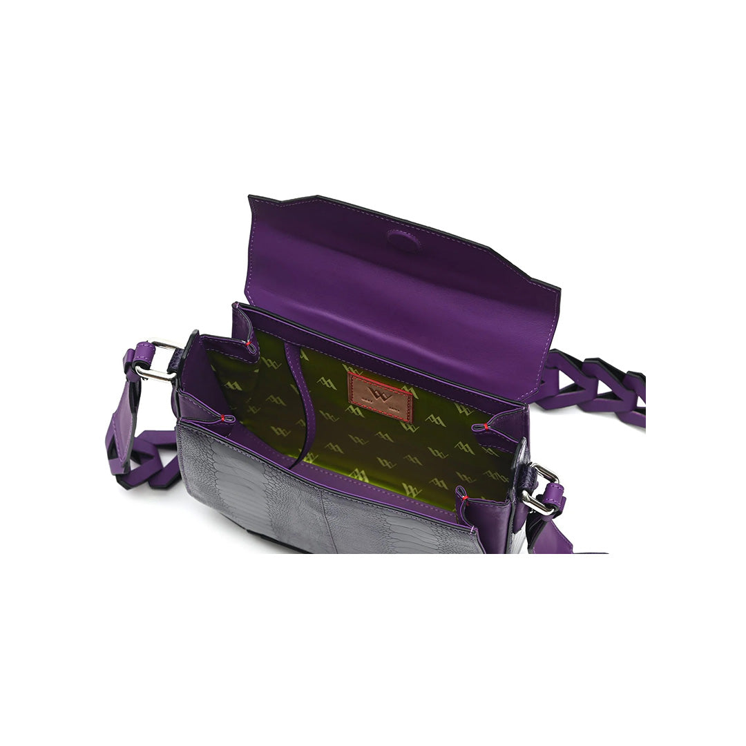 A grape purple leather handbag with a structured design, featuring a removable and adjustable link strap, a magnetic top closure, and a brand label on the interior.