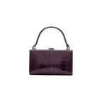 A purple leather purse with a solid pattern, featuring a hand carry and a link strap.