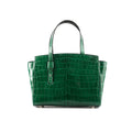 An emerald green, crocodile patterned leather handbag with a sleeve-style handle and a magnetic closure flap.