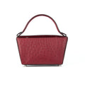 A red leather handbag with a structured handle and a detachable strap, featuring a textured exterior and a sleek design.