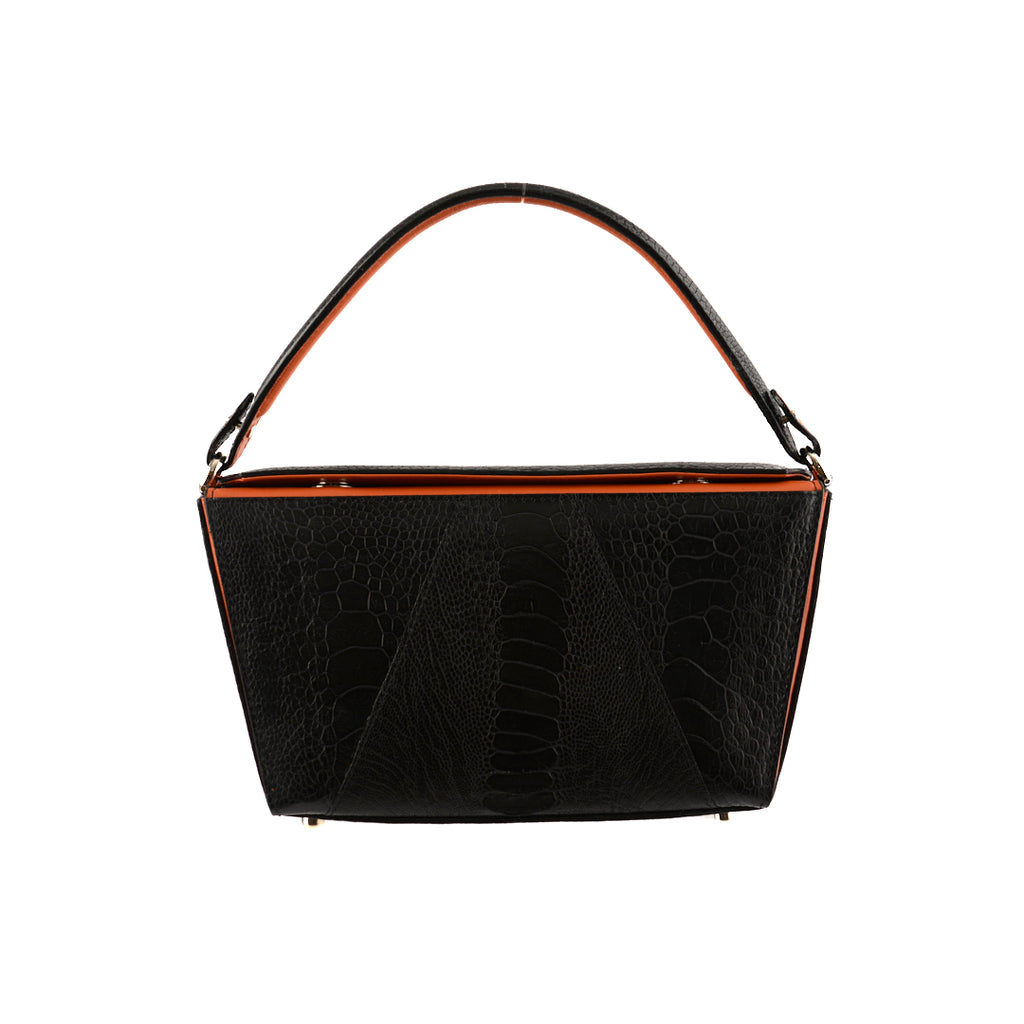 A black handbag with orange gussets and a removable brown strap, featuring a sleek and minimalistic design.