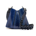 A blue crocodile-embossed leather shoulder bag with a black braided leather strap and black leather trim, shown on a white background.