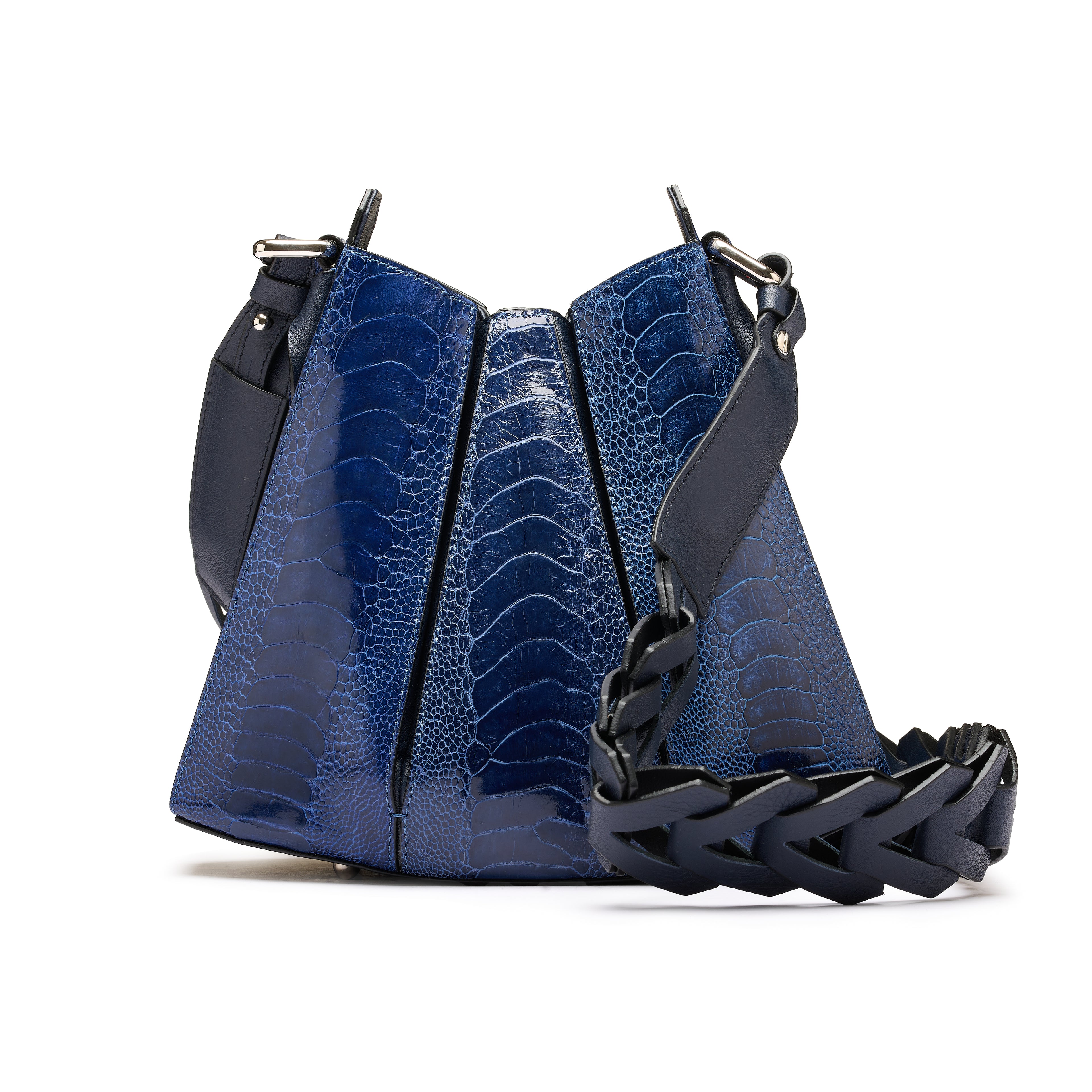 A blue crocodile-embossed leather shoulder bag with a black braided leather strap and black leather trim, shown on a white background.