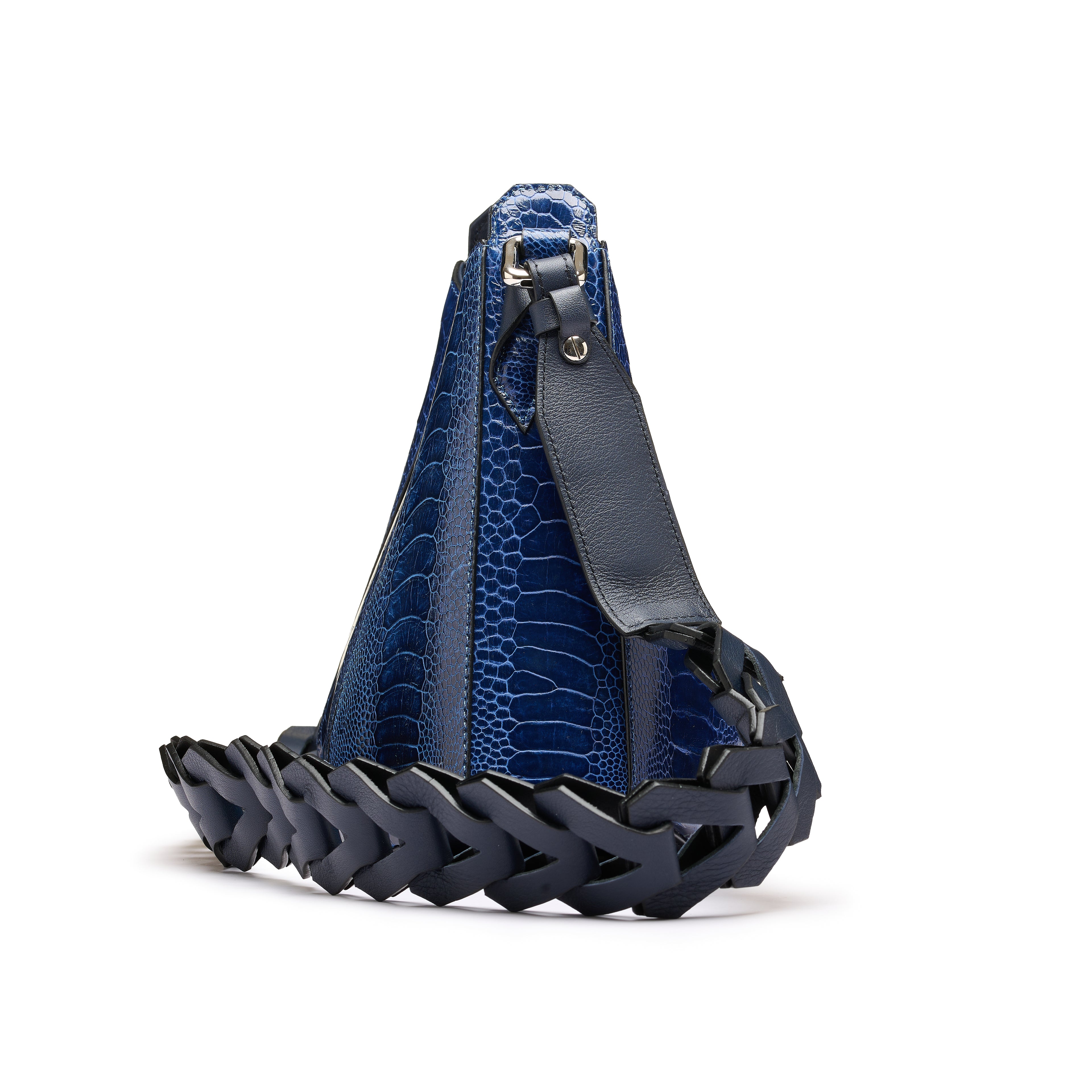 A blue crocodile-embossed leather shoulder bag with a dark navy braided leather base and strap, shown from a side angle on a white background.