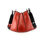 A red handbag with black gussets, featuring a tulip closure design, with a removable link strap.