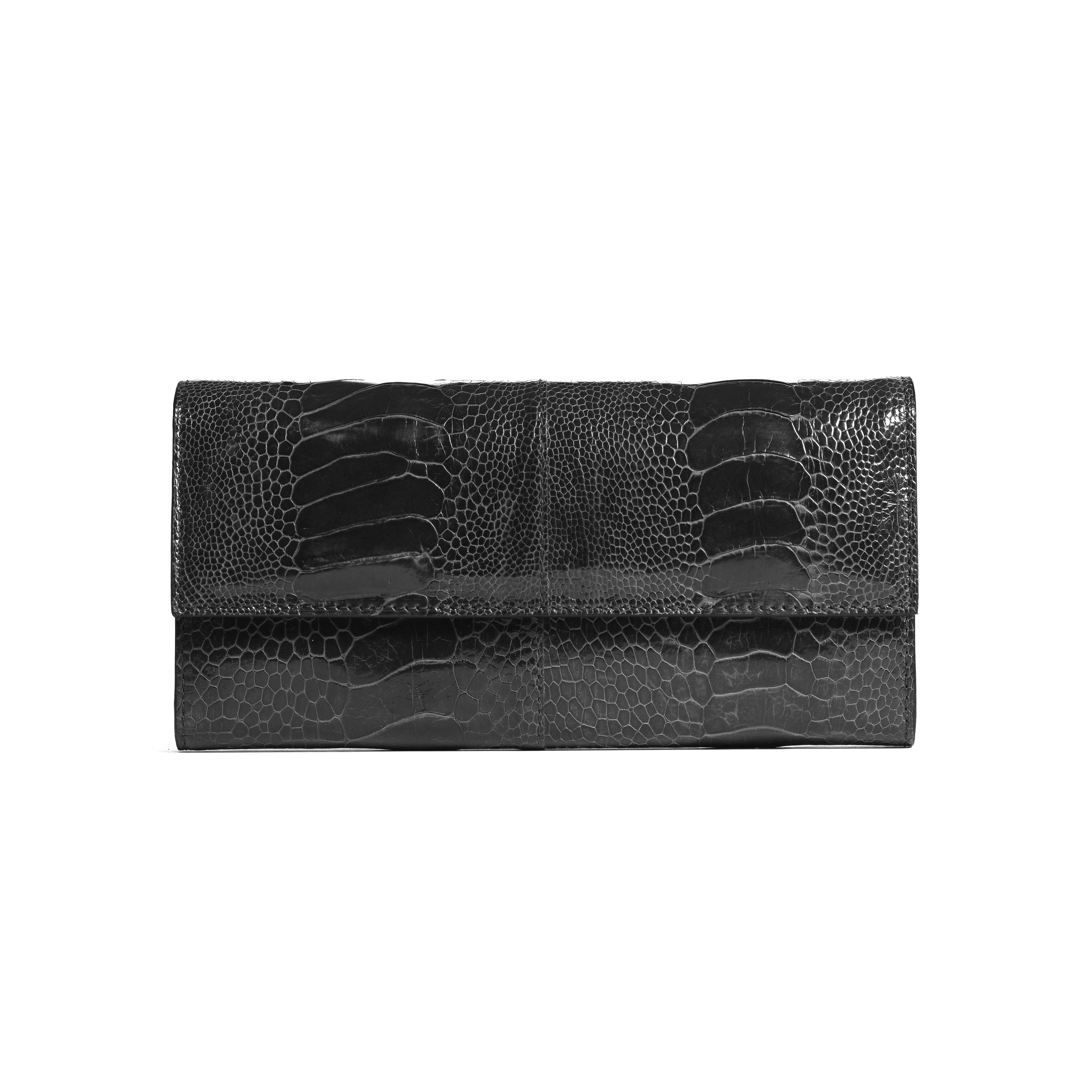 A black crocodile-embossed leather clutch wallet, shown flat against a solid white background.