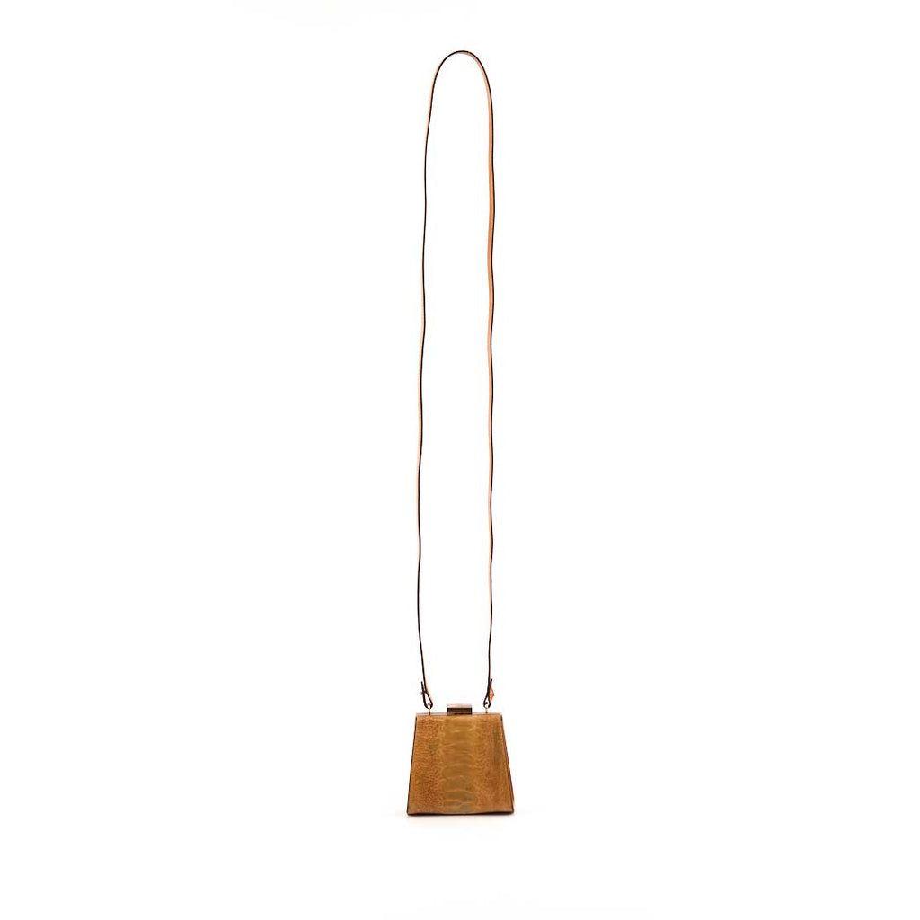 Wooden cowbell with a long leather strap on a white background