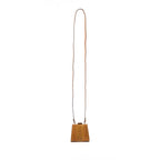 Wooden cowbell with a long leather strap on a white background