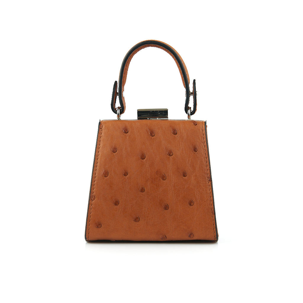 A cognac brown leather small clutch purse with a zipper top closure and a detachable handle.