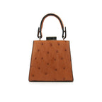 A cognac brown leather small clutch purse with a zipper top closure and a detachable handle.