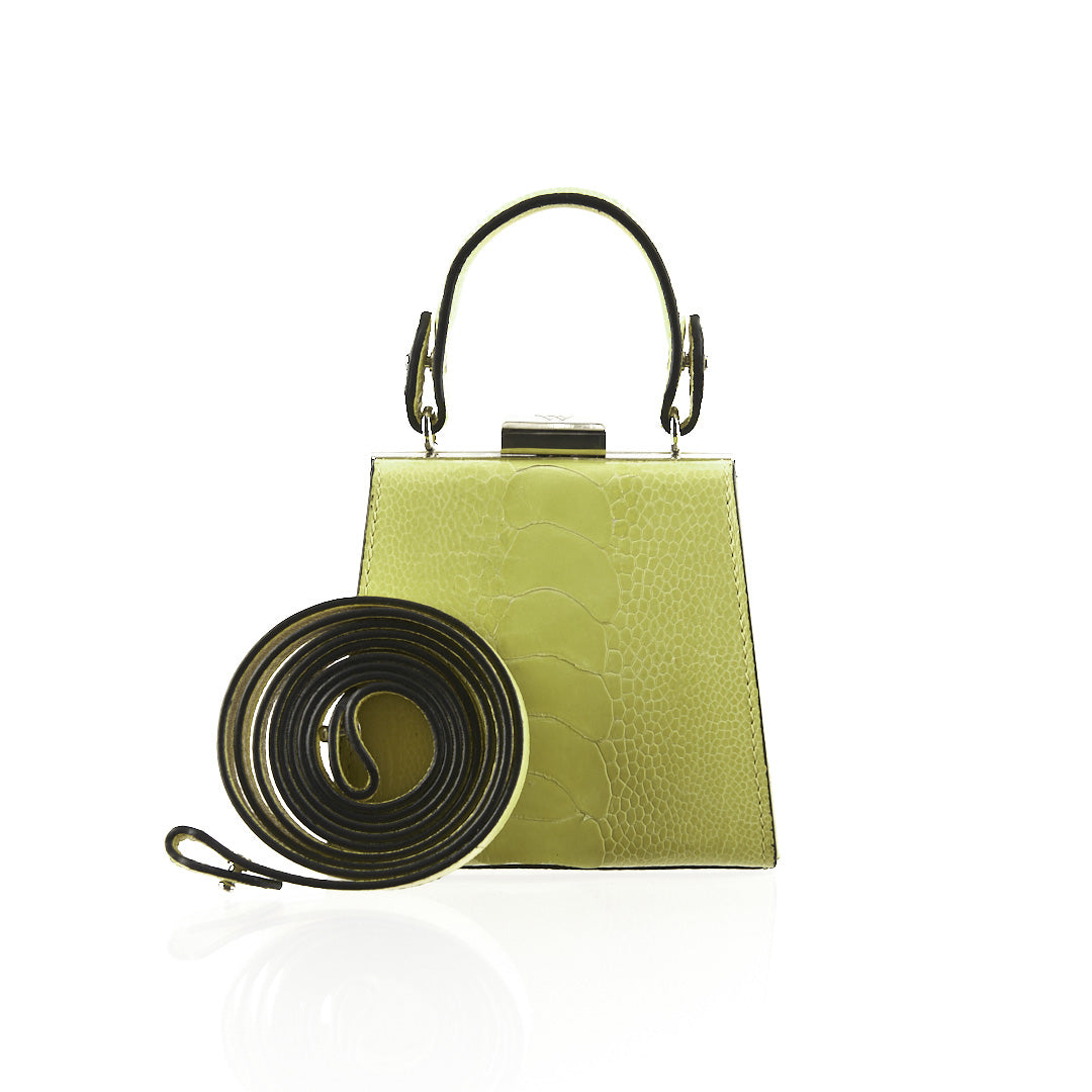 A lime green textured leather handbag with a black top handle and a matching black detachable shoulder strap, displayed on a clean white background.