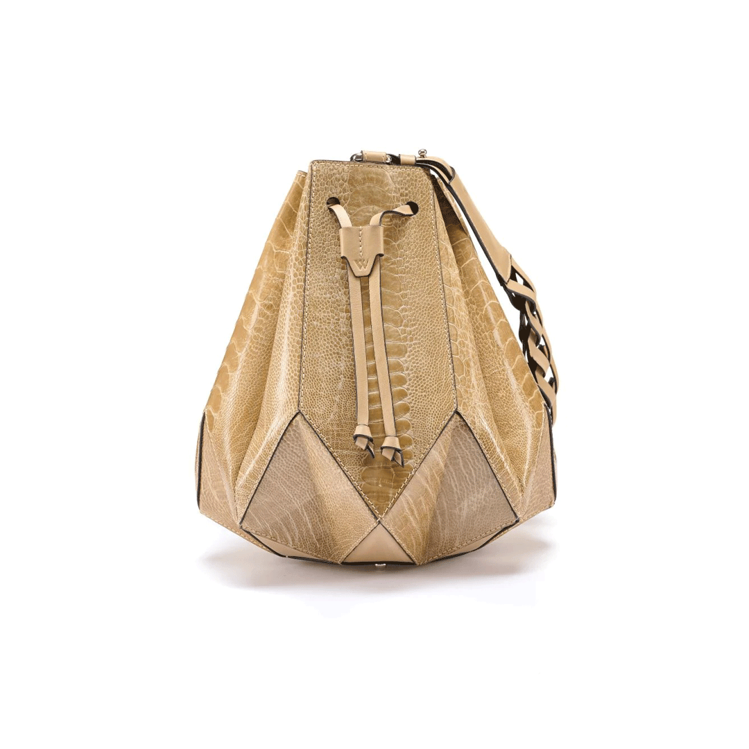 A beige and brown leather handbag with a geometric design and a drawstring top closure, resembling a star.