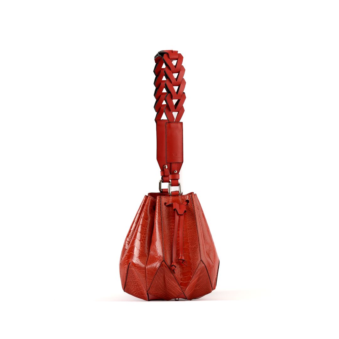 A red leather handbag with an unique star-like shape and a drawstring closure resembling a blossoming flower.