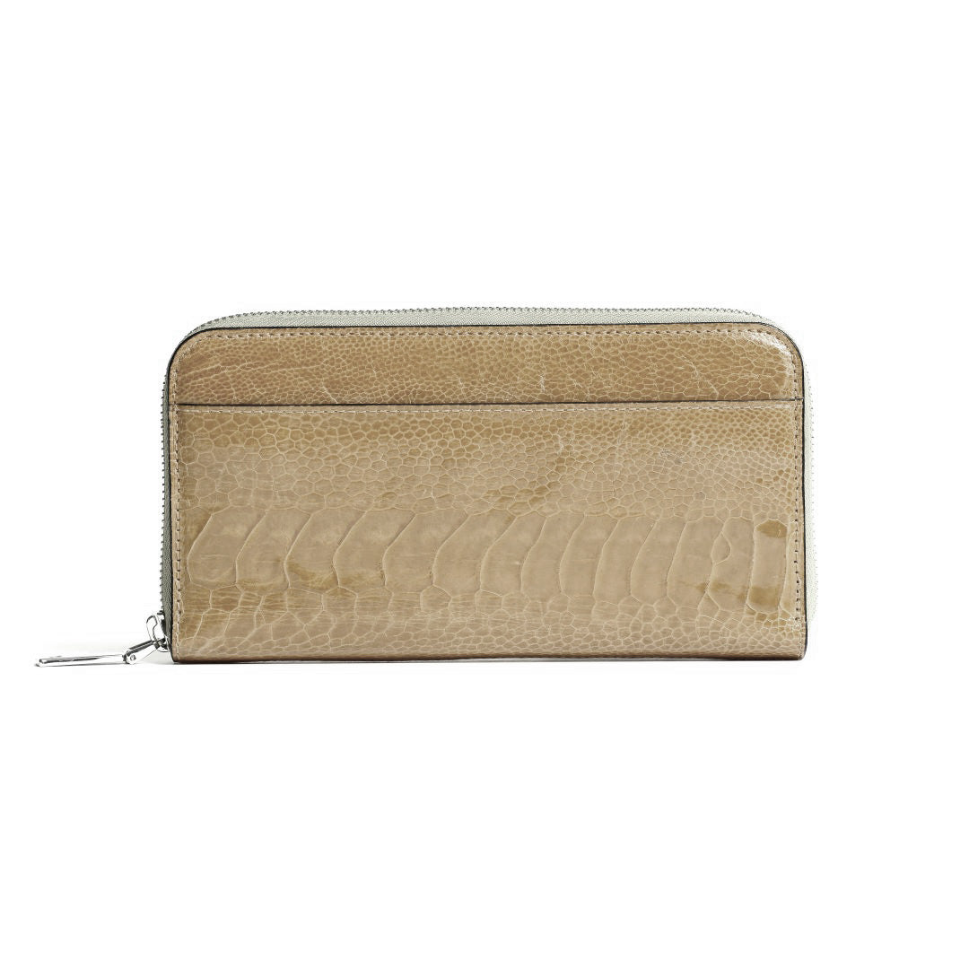 A beige zip-around wallet with a glossy crocodile-embossed texture, featuring a horizontal card slot on the front and silver-tone zipper hardware, shown against a plain white background.