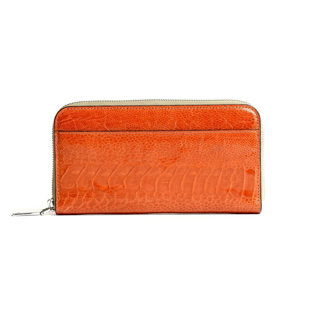 An orange wallet with a textured ostrich leg leather surface and a zipper closure.